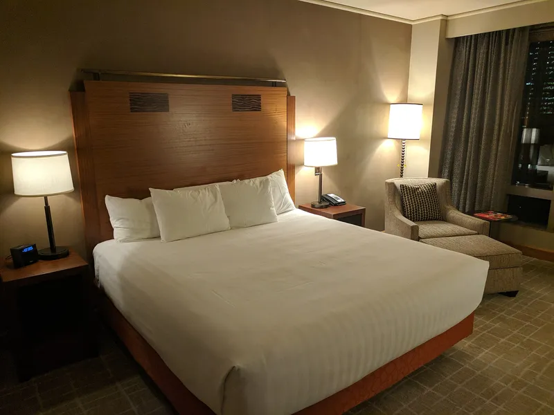 Aufgeraeumtes Hotelzimmer mit gemachtem Doppelbett
